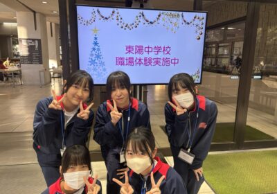 自分達で制作したデジタルサイネージの前で